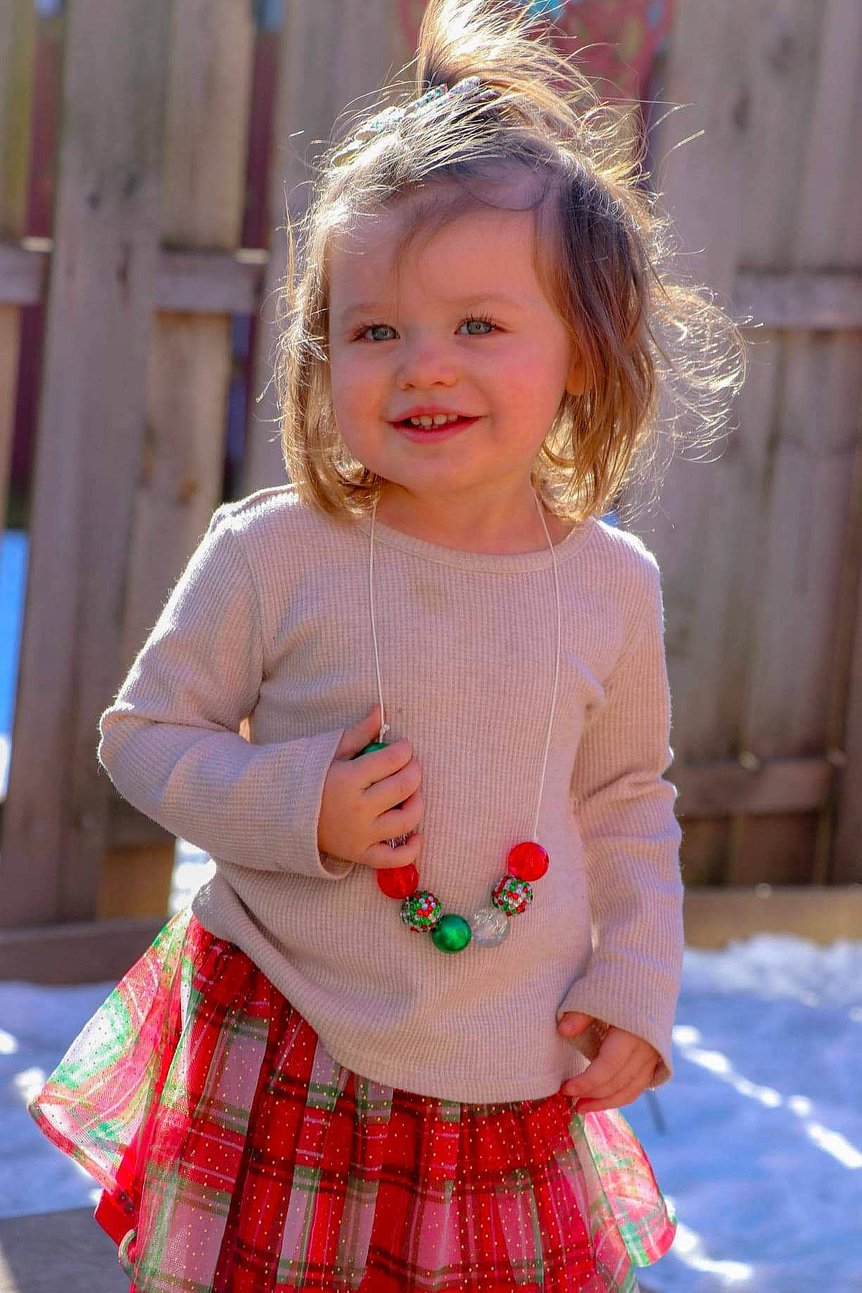 Vada is registered to the contest to win money with this photo: arm, baby_toddler_clothing, child, facial_expression, hair, hand, happy, joy, lip, people, person, photograph, pink, plaid, skin, sleeve, smile, standing, summer, tartan