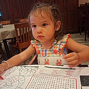 Brylee joined the competition — help win amazing prizes! child, toddler, girl, portrait, restaurant, table, coloring, crayon, placemat, drawing, seated, dress, smiling, indoors, chairs, dining_area, checkerboard, food_service, brown_hair, focused