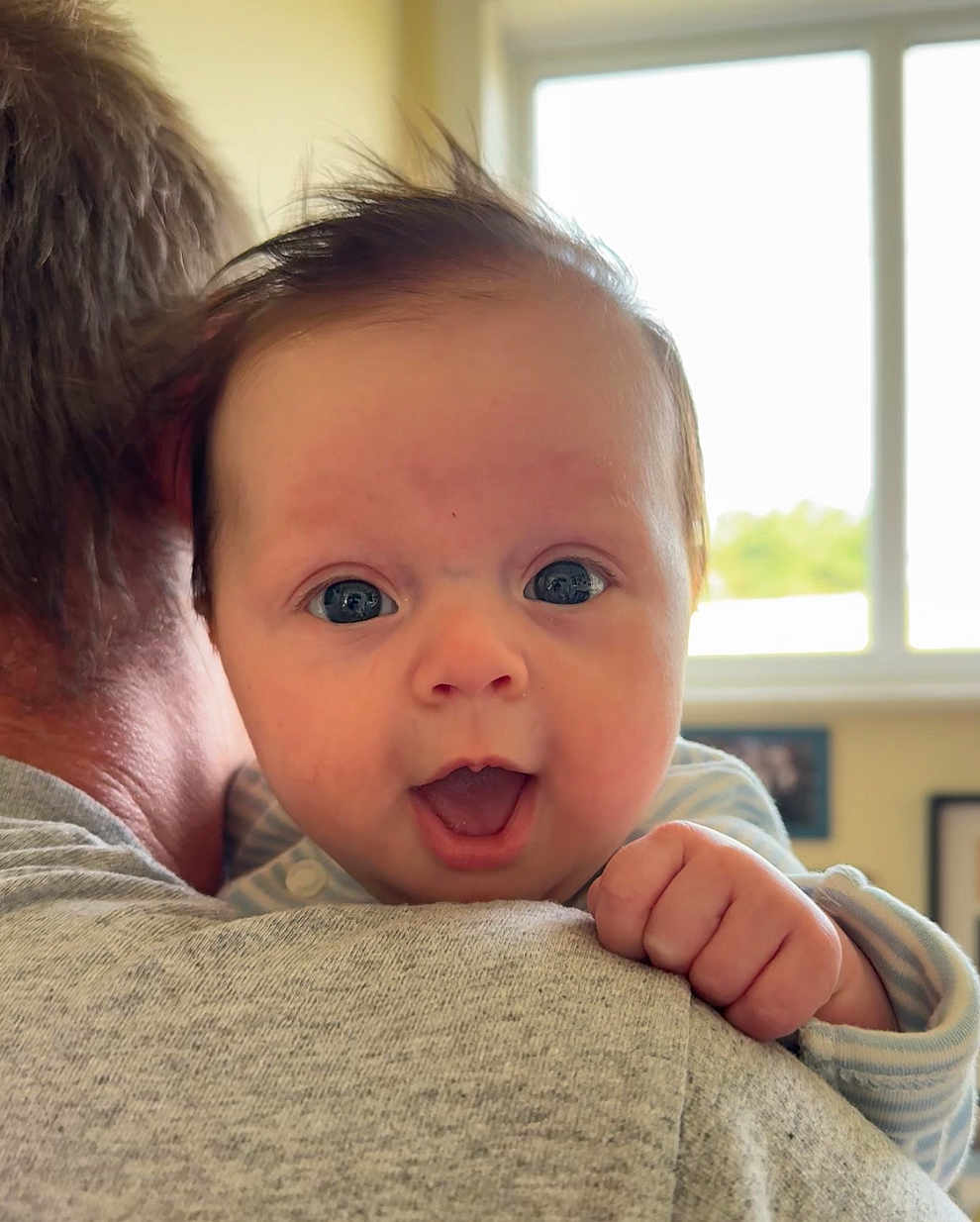Rosie joined the competition — help win amazing prizes! baby, infant, face, expression, hand, hair, person, shoulder, adult, clothing, window, indoor, light, skin, portrait, cute, happy, smile, home, background