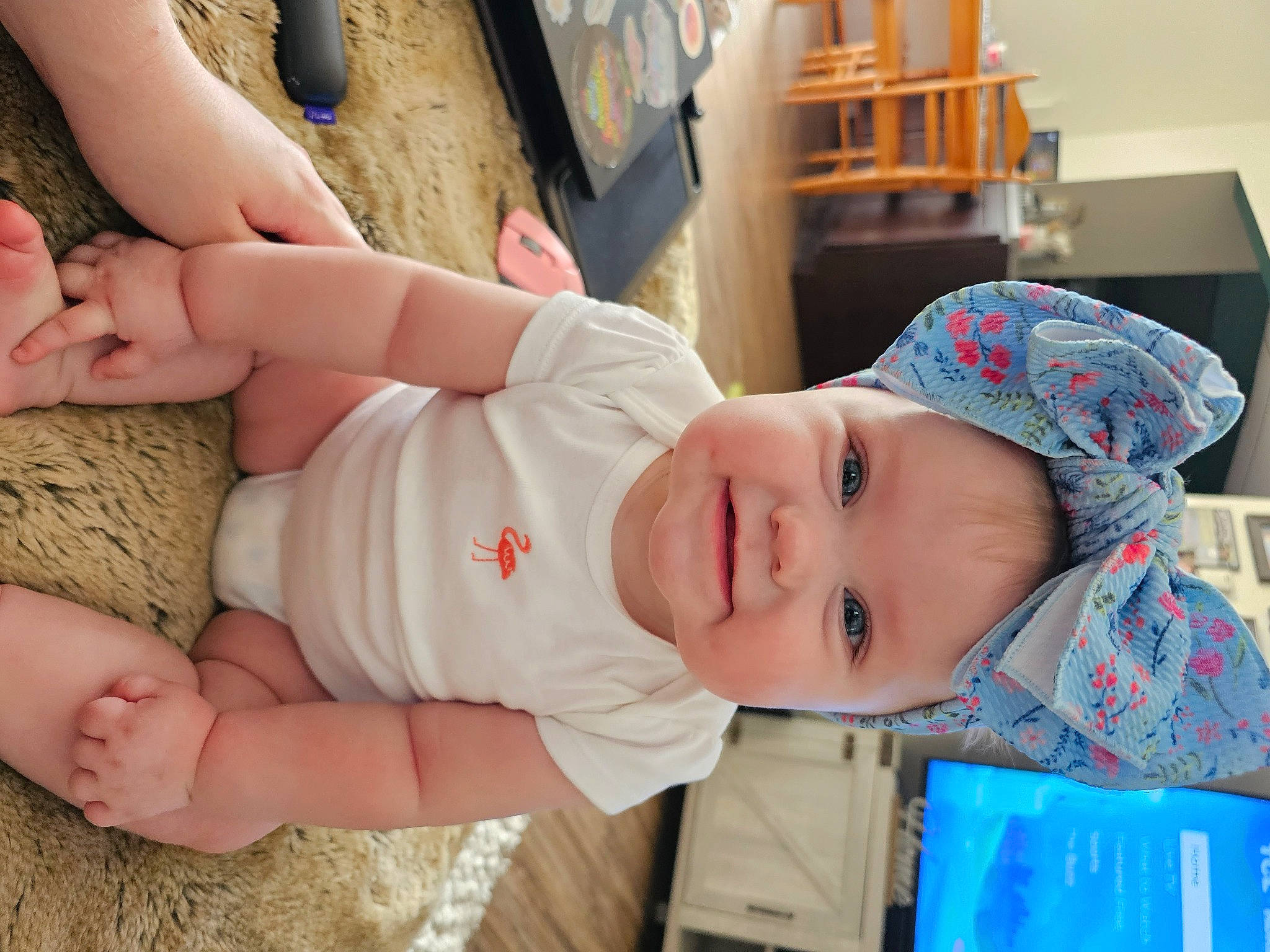 Daisy is registered to the contest to win money with this photo: baby, baby_toddler_clothing, child, comfort, eye, finger, fun, gesture, happy, hat, headwear, human_leg, joy, knee, mouth, person, room, skin, smile, thigh