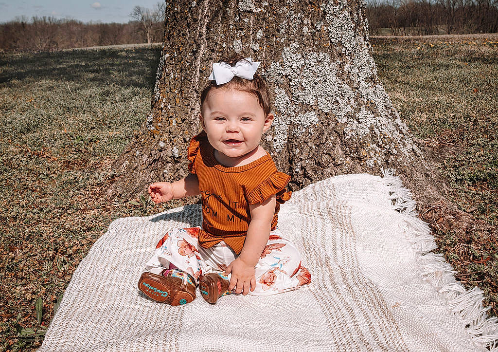Gracelynn joined the competition — help win amazing prizes! baby, baby_toddler_clothing, child, dress, flash_photography, fun, grass, grass_family, happy, hat, leaf, leisure, people_in_nature, person, plant, sitting, smile, toddler, tree, wood