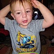 Bellamy is registered to the contest to win money with this photo: child, toddler, indoor, toy, tshirt, excavator, hands_up, curly_hair, play, face, brown_eyes, earring, carpet, table, colorful, furniture, expression, person, young, cute