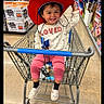 toddler, child, shopping_cart, red_hat, cowboy_hat, store, aisle, clothing, smiling, playful, footwear, person, retail, indoor, shopping, casual_wear, fun, young_child, hat, happy