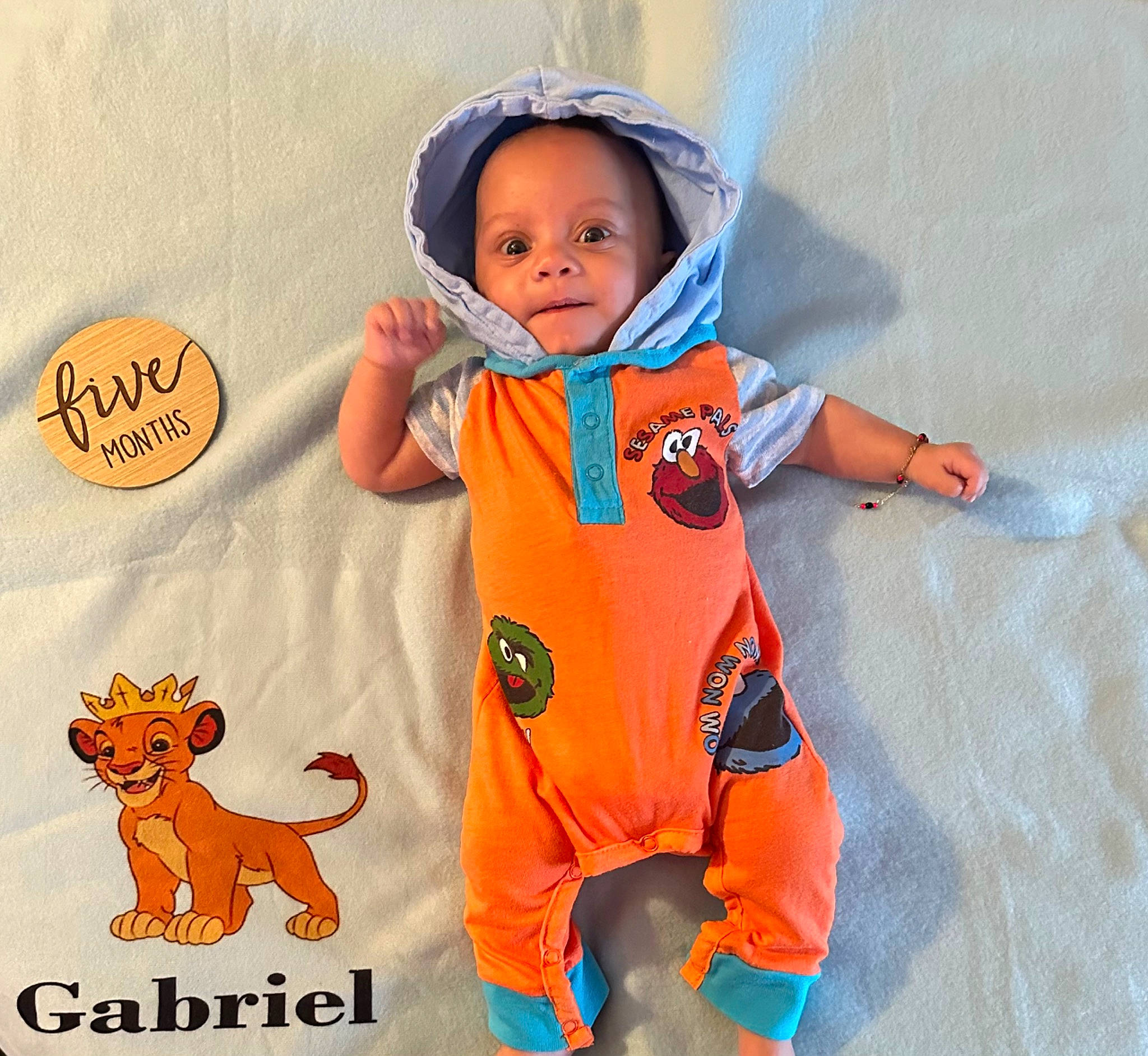 Gabriel is registered to the contest to win money with this photo: art, baby, baby_products, baby_toddler_clothing, child, electric_blue, face, felidae, flooring, font, happy, orange, pattern, peach, person, sleeve, t_shirt, tail, textile, thumb