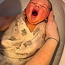 baby, newborn, yawning, wrapped, cloth, bath, water, hand, arm, skin, infant, cute, sleepy, care, parent, tender, closeup, face, expression, soft_lighting