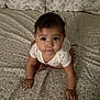 baby, crawling, bed, pillow, pattern, infant, child, cute, indoors, person, clothing, face, hands, eyes, drool, expression, young, sleeping_area, blanket, soft