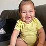 baby, child, smiling, yellow_onesie, sitting, couch, happy, infant, hair_tuft, indoor, skin, face, cute, portrait, small_hand, small_foot, chubby, person, young, bright_eyes