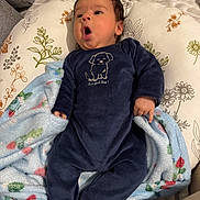 Omar participe au concours pour gagner de l'argent avec cette photo : baby, infant, onesie, blanket, pillow, bed, face, expression, cute, clothing, blue, navy, floral, soft, sleep, lying_down, indoors, child, newborn, cozy