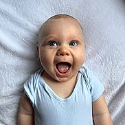 Jaxon joined the competition — help win amazing prizes! baby, infant, blue_eyes, onesie, smiling, happy, lying_down, blanket, soft_texture, cute, human, child, portrait, skin, head, mouth_open, small_hands, cheeks, expression, indoors