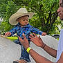 Charvis Jr joined the competition — help win amazing prizes! child, baby, cowboy_hat, plaid_shirt, jeans, boots, horse, white_horse, adult, hands, outdoor, tree, greenery, park, nature, person, animal, daylight, safety, playful