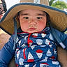 baby, child, sunhat, blue_outfit, patterned_clothing, face, outdoor, sky, greenery, person, hand, adult, holding, summer, cute, portrait, expression, sunny, day, casual