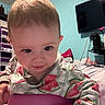 Riley is registered to the contest to win money with this photo: baby, background, bedding, bedroom, child, clothing, cute, expression, face, furniture, hand, head, indoor, pajamas, person, room, smile, television, watermelon_pattern, young_child