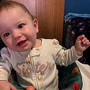 Riley is registered to the contest to win money with this photo: baby, child, closeup, clothing, cute, expression, face, hands, happy, head, indoor, infant, onesie, person, play, portrait, seat, smile, toy, young