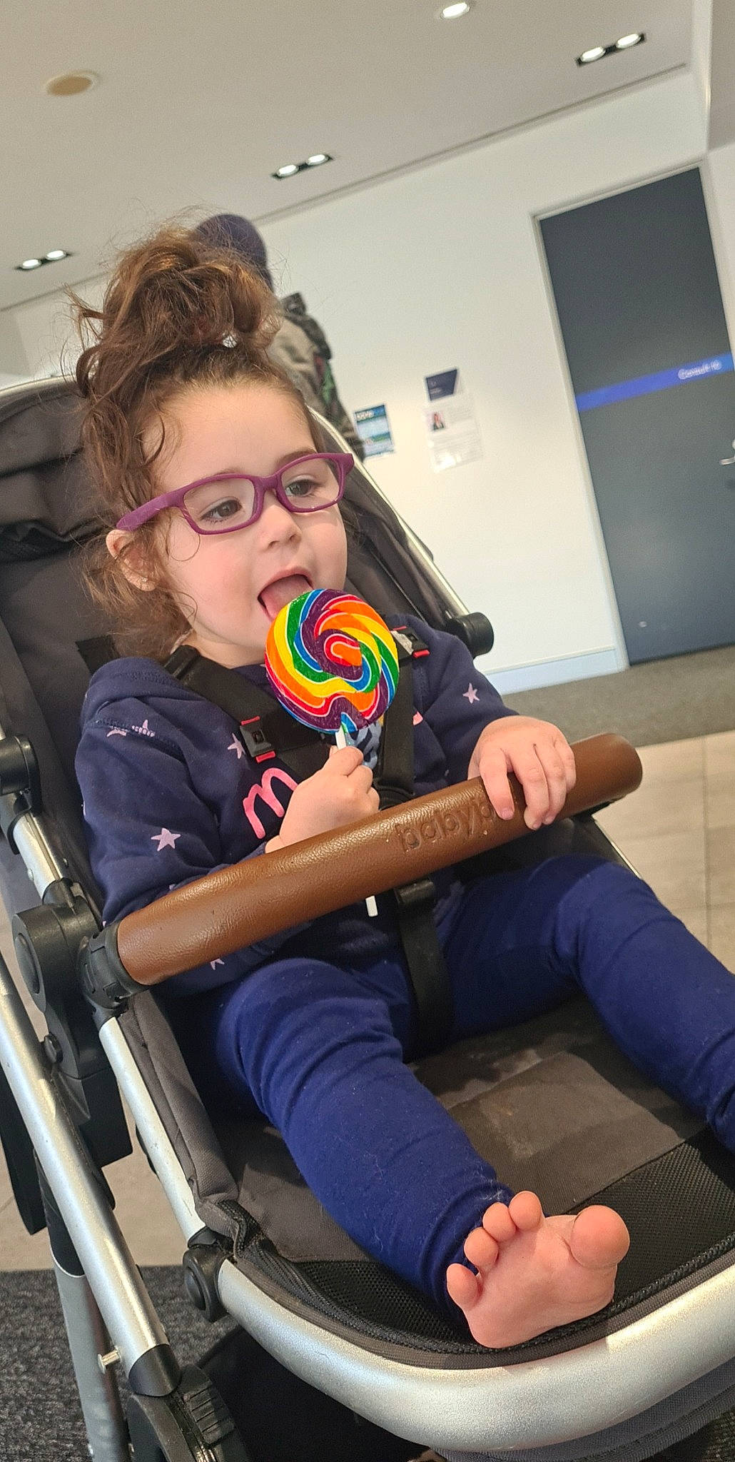 Everley is registered to the contest to win money with this photo: arm, audio_equipment, automotive_design, chair, child, engineering, eyewear, fun, glasses, hearing, human_leg, leisure, motor_vehicle, person, personal_protective_equipment, play, room, sitting, t_shirt, thigh