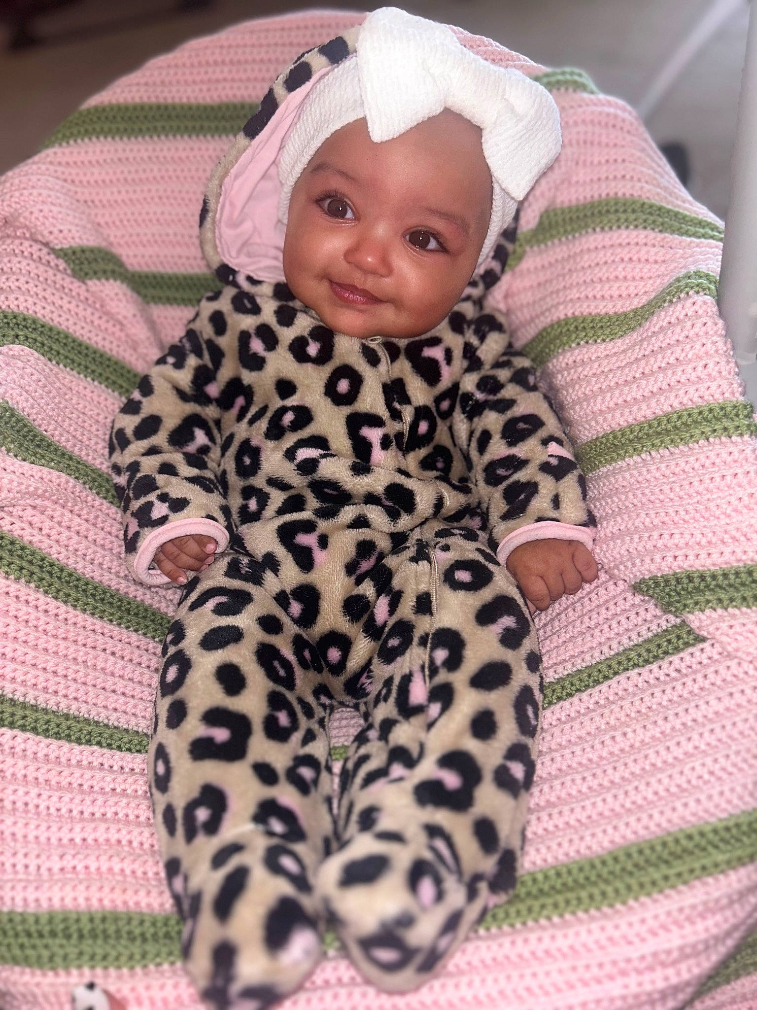 Tynliegh is registered to the contest to win money with this photo: baby, baby_toddler_clothing, cap, cheek, child, comfort, face, facial_expression, head, headwear, linens, magenta, mammal, outerwear, pattern, person, pink, skin, sleeve, smile