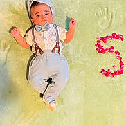 Arvik joined the competition — help win amazing prizes! baby, child, infant, suspenders, bow_tie, hat, flower_petals, green_blanket, handprints, number_five, cute, portrait, lying_down, celebration, soft_texture, clothing, fashion, adorable, young, face