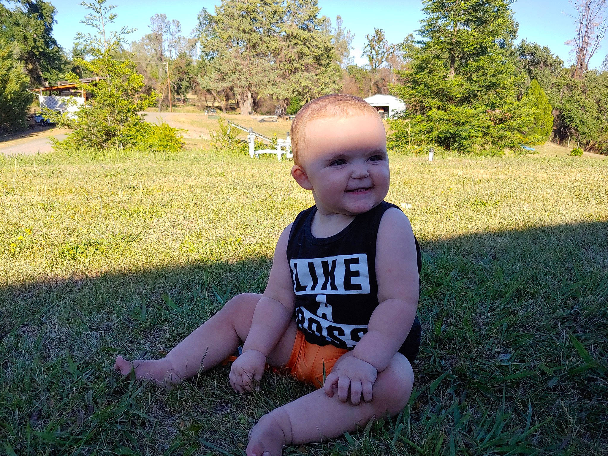 Sydney is registered to the contest to win money with this photo: baby, baby_toddler_clothing, botany, fun, grass, grass_family, grassland, happy, lawn, leaf, leisure, meadow, people_in_nature, person, plant, sky, smile, sunlight, t_shirt, toddler