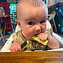 Noah joined the competition — help win amazing prizes! baby, child, high_chair, cucumber, eating, food, restaurant, table, indoor, person, face, hand, clothing, seat, furniture, curious, closeup, young, infant, portrait