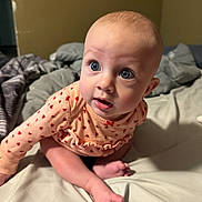 Mackenzie joined the competition — help win amazing prizes! baby, infant, blue_eyes, sitting, bed, blanket, clothing, long_sleeve, peach, ladybug_pattern, curious, indoors, skin, foot, hand, head, expression, portrait, child, cute