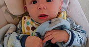Wyatt is registered to the contest to win money with this photo: baby, bib, blanket, blue, child, clothing, comfort, cozy, curious, cute, expression, face, hands, indoor, infant, padded_seat, portrait, soft, warm, young