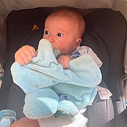 Mylow participe au concours pour gagner de l'argent avec cette photo : baby, blanket, car_seat, pacifier, infant, child, clothing, seat, person, soft_toy, blue_blanket, hands, legs, looking_away, indoors, cute, newborn, light, shadow, comfort