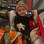 aisle, baby, blanket, child, clothing, cute, face, food, footwear, groceries, grocery_store, hat, indoor, mickey_mouse, person, retail, shopping, shopping_cart, smile, sweater