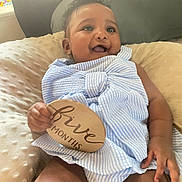 Zenaaliyah is registered to the contest to win money with this photo: baby, infant, smile, child, blue_striped_clothing, plaque, five_months, hand, pillow, couch, indoor, cute, happy, skin, face, sitting, soft_texture, person, young_child, portrait
