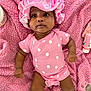 baby, infant, pink_clothing, polka_dot, bonnet, blanket, soft_texture, lying_down, cute, child, skin, indoors, baby_care, sock, headwear, apparel, person, face, expression, newborn