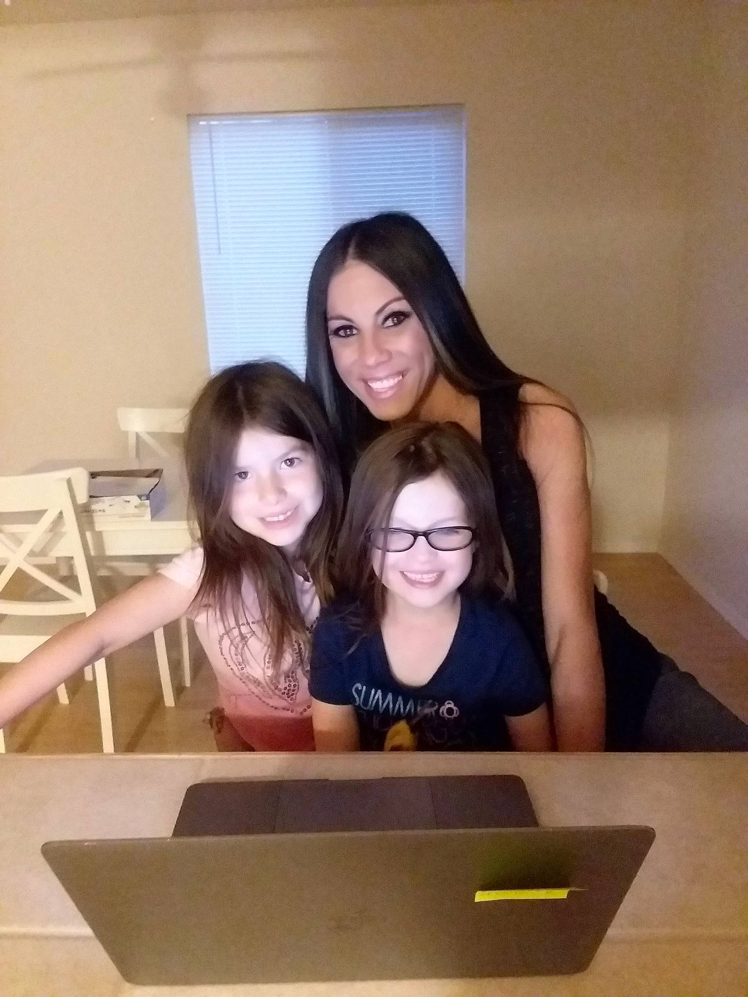 Kinsey is registered to the contest to win money with this photo: chair, child, electronic_device, event, eyewear, flooring, fun, gadget, happy, joy, laptop, leisure, netbook, person, selfie, sitting, smile, t_shirt, table, tableware