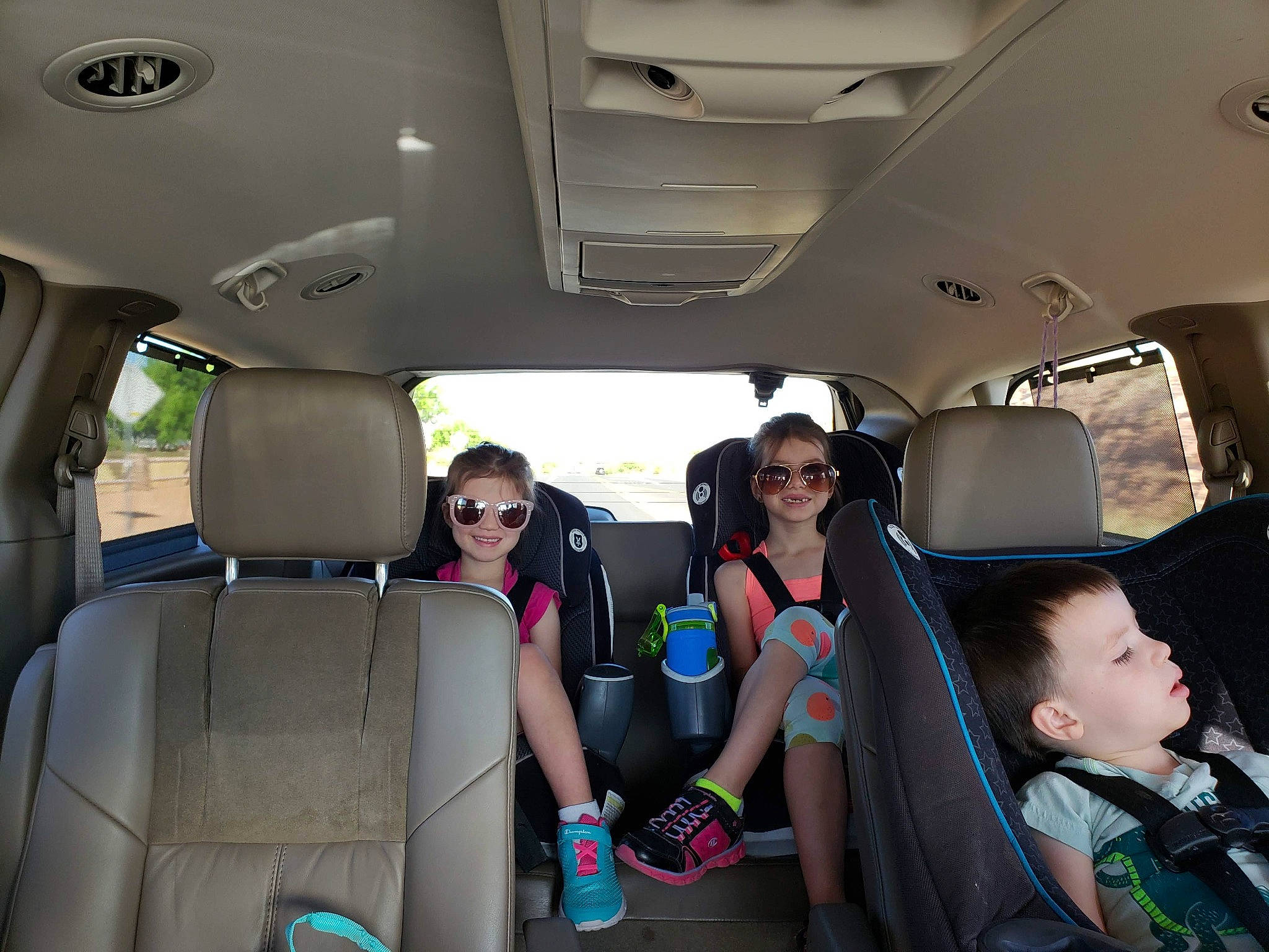 Kinsey is registered to the contest to win money with this photo: air_travel, automotive_design, automotive_exterior, car_seat, car_seat_cover, eyewear, fun, goggles, hat, head_restraint, joy, motor_vehicle, person, seat_belt, shorts, smile, sunglasses, travel, vehicle, vehicle_door