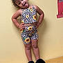 Oaklynn is registered to the contest to win money with this photo: child, curly_hair, tongue_out, yellow_wall, sunflower_print, leopard_print, matching_outfit, shorts, tank_top, black_slippers, standing, playful, indoor, smiling, cute, pose, person, fashion, happy, cheeky