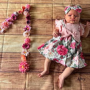 Victoire participe au concours pour gagner de l'argent avec cette photo : baby, infant, flower, headband, dress, floral_pattern, number_one, wooden_floor, flooring, celebration, birthday, cute, child, laying_down, pink, decor, fabric, person, young_child, portrait