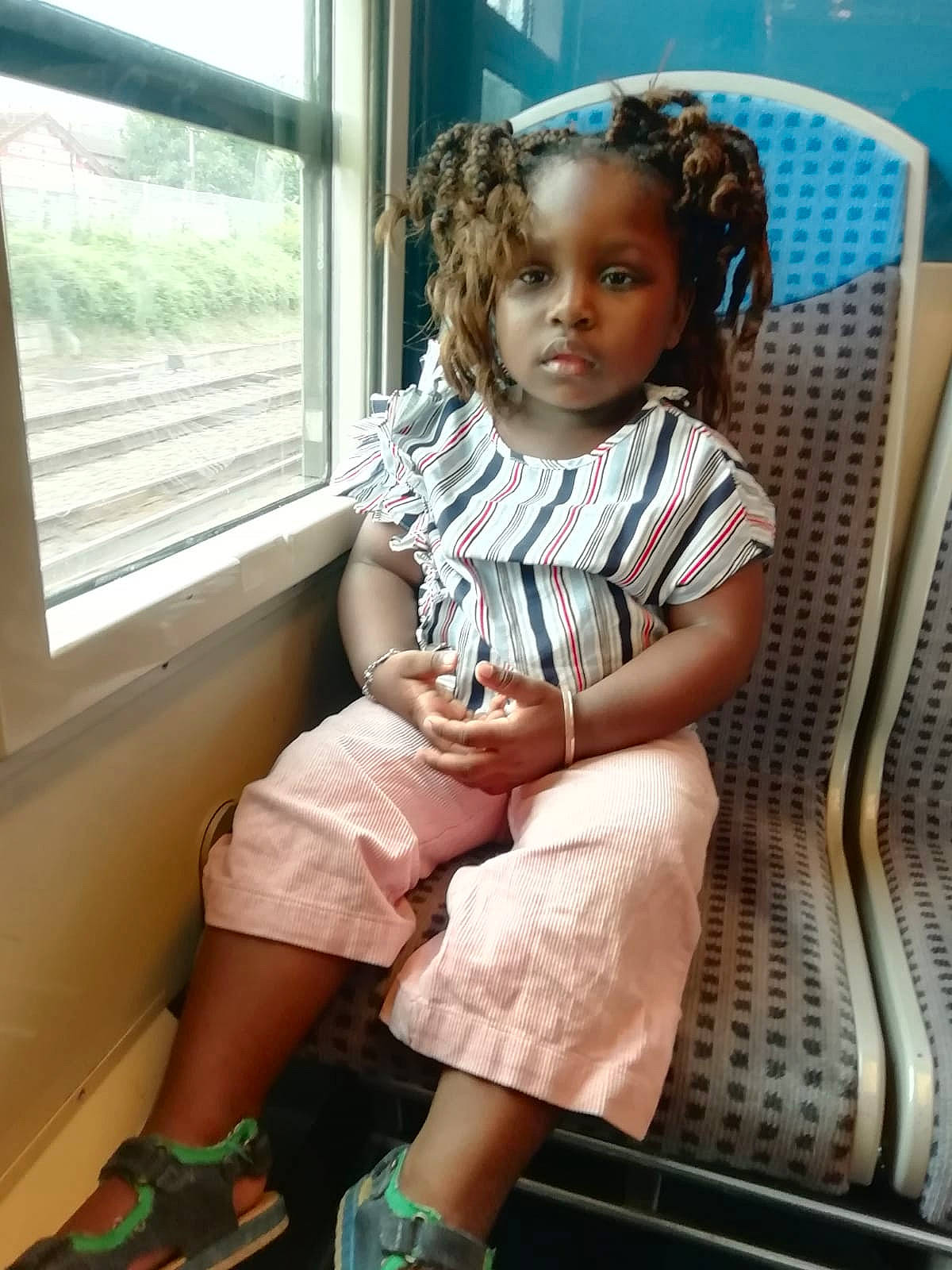 Nolwene a rejoint le concours — aidez-le/la à gagner de superbes lots ! baby_toddler_clothing, chair, child, day_dress, fashion_design, fun, human_leg, knee, leg, long_hair, pattern, person, room, sandal, sitting, skin, sock, thigh, toddler, vacation