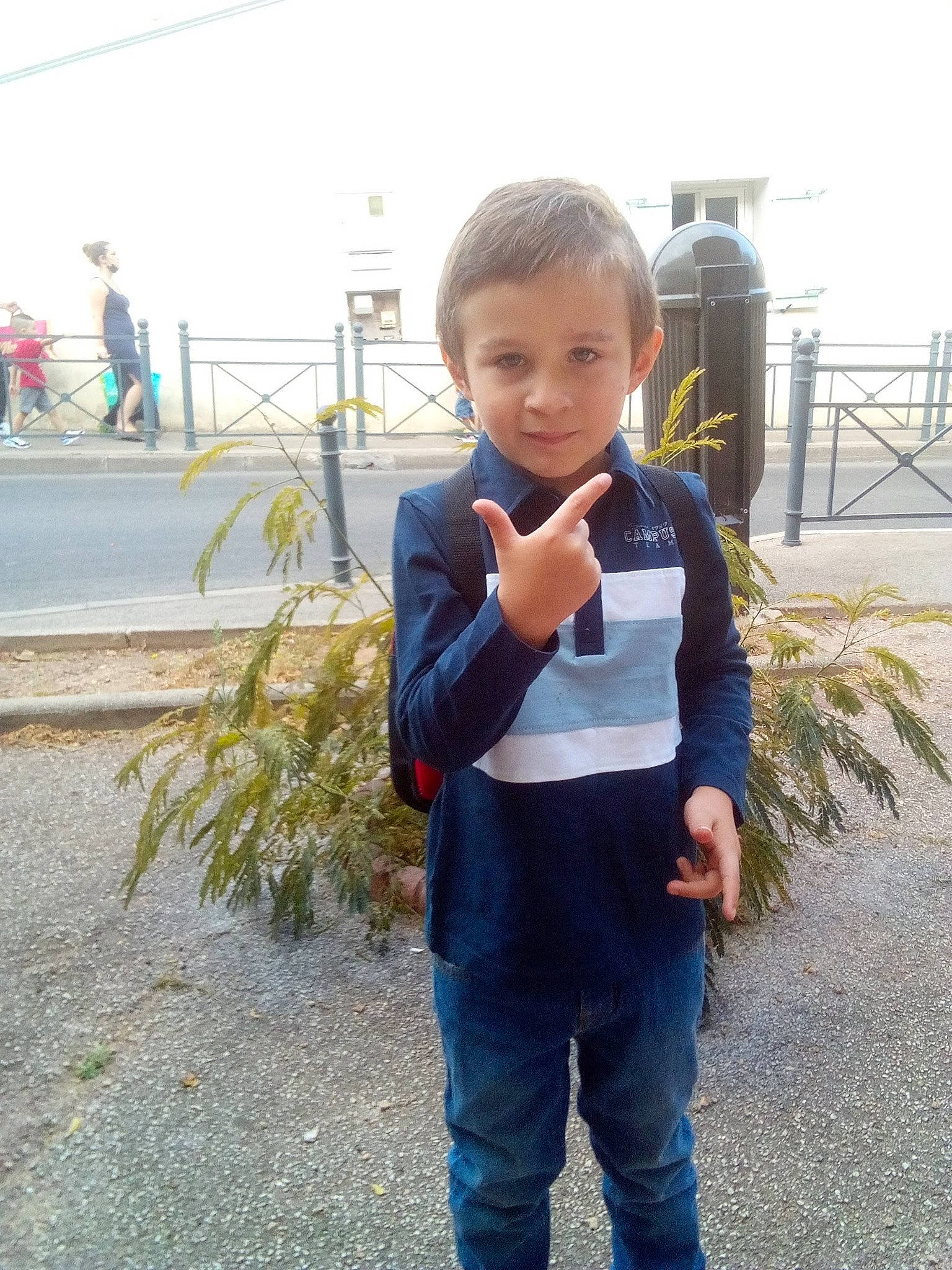 Angelo participe au concours pour gagner de l'argent avec cette photo : asphalt, child, city, clothing, denim, electric_blue, fun, gesture, grass, leisure, person, plant, recreation, sitting, sky, sleeve, t_shirt, toddler, travel, vacation