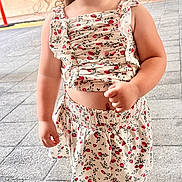 Kaylee is registered to the contest to win money with this photo: child, girl, curly_hair, pigtails, floral_outfit, top, skirt, shoes, standing, pavement, outdoor, portrait, cute, young_child, fashion, daylight, expression, person, casual_clothing, street