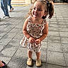 Kaylee is registered to the contest to win money with this photo: child, girl, smiling, pigtails, curly_hair, floral_dress, beige_shoes, sidewalk, urban, people, walking, building, entrance, casual, outdoor, daylight, happy, portrait, fashion, person