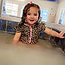 Kaylee joined the competition — help win amazing prizes! child, smiling, swimsuit, leopard_print, wet_hair, indoor_pool, water, splashing, edge, holding, happy, portrait, young_child, playful, bright, natural_light, windows, ceiling, room, fun