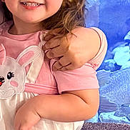 Kaylee is registered to the contest to win money with this photo: child, girl, smiling, curly_hair, dress, bunny_print, arm, hug, blue_background, aquarium, rocks, happy, portrait, indoor, cute, person, clothing, animal_print, baby, young