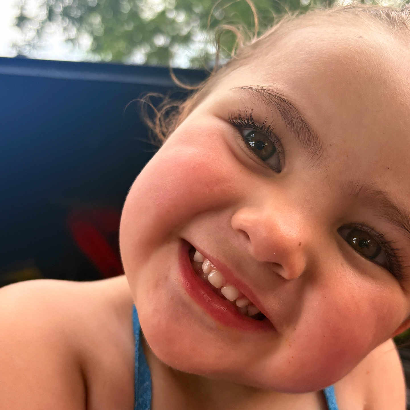 Kaylee joined the competition — help win amazing prizes! child, toddler, smile, face, happy, closeup, outdoor, blue_clothing, eyelashes, skin, portrait, young_child, cheeks, summer, nature, daylight, cute, person, head, expression