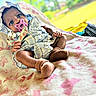 baby, pacifier, blanket, outdoor, infant, clothing, headwear, sock, cute, portrait, skin, hand, footwear, fabric, pattern, nature, relaxing, daylight, person, babywear