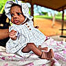 Coreyanna is registered to the contest to win money with this photo: baby, infant, child, dress, bonnet, sock, blanket, outdoor, pavilion, portrait, cute, person, skin, hand, footwear, sitting, expression, nature, daylight, furniture