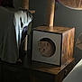 Hiro is registered to the contest to win money with this photo: cat, wooden_cube, cat_tree, indoor, furniture, dark, cozy, pet, animal, curious, circular_opening, wood, soft_fabric, domestic, resting, side_view, quiet, feline, home, shadow