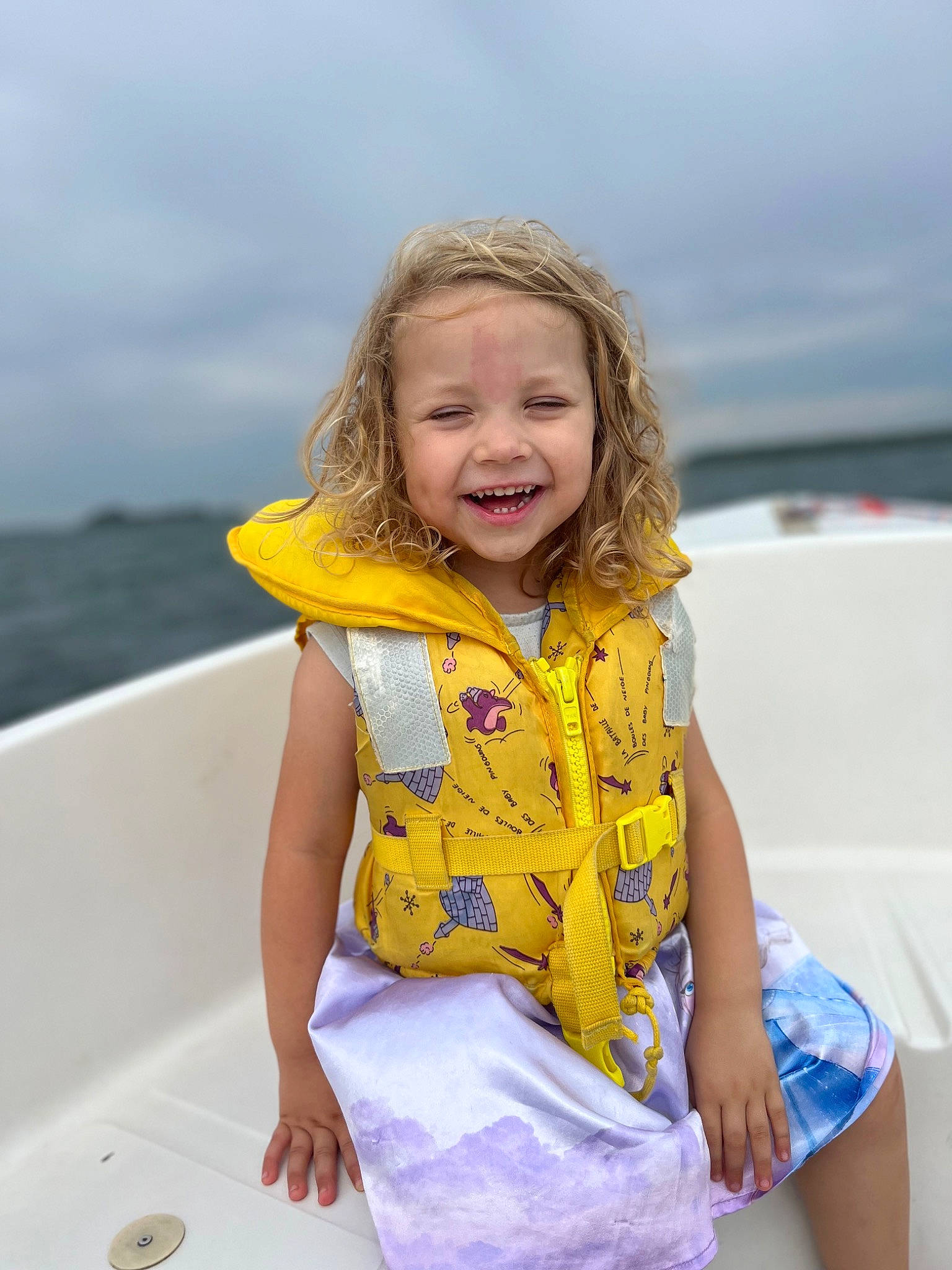 Elise participe au concours pour gagner de l'argent avec cette photo : blond, boat, boats_and_boating_equipment_and_supplies, child, cloud, fun, hair, happy, joy, leisure, lifejacket, person, recreation, sitting, skin, sky, sleeve, smile, summer, toddler