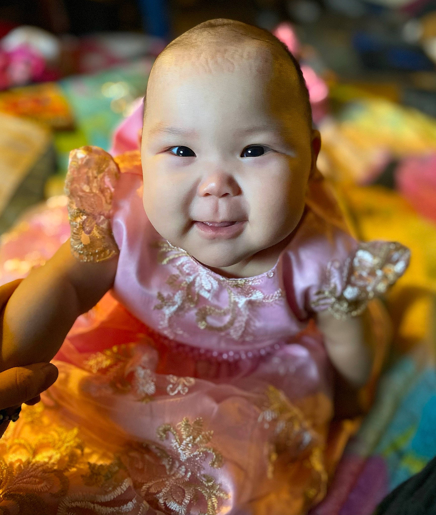 Adele is registered to the contest to win money with this photo: baby, baby_toddler_clothing, cheek, child, dress, embellishment, event, facial_expression, fun, happy, iris, leisure, peach, person, pink, sitting, skin, smile, sweetness, toddler
