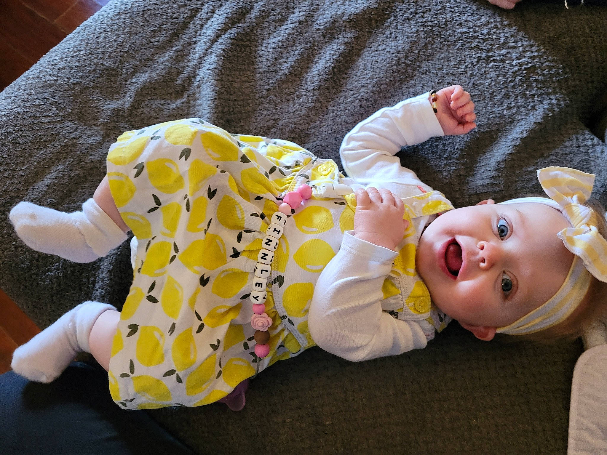Finnley is registered to the contest to win money with this photo: baby, baby_products, baby_toddler_clothing, cheek, child, comfort, flooring, happy, head, mammal, orange, person, pink, room, sitting, skin, sleeve, smile, textile, toddler