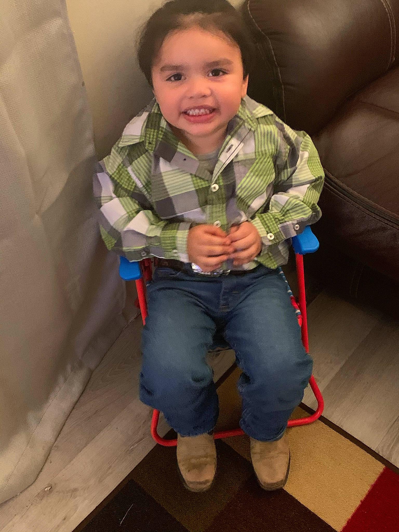Jose is registered to the contest to win money with this photo: baby_toddler_clothing, cheek, child, comfort, denim, floor, flooring, fun, hardwood, head, joy, nose, pattern, person, sitting, skin, sleeve, smile, sneakers, toddler