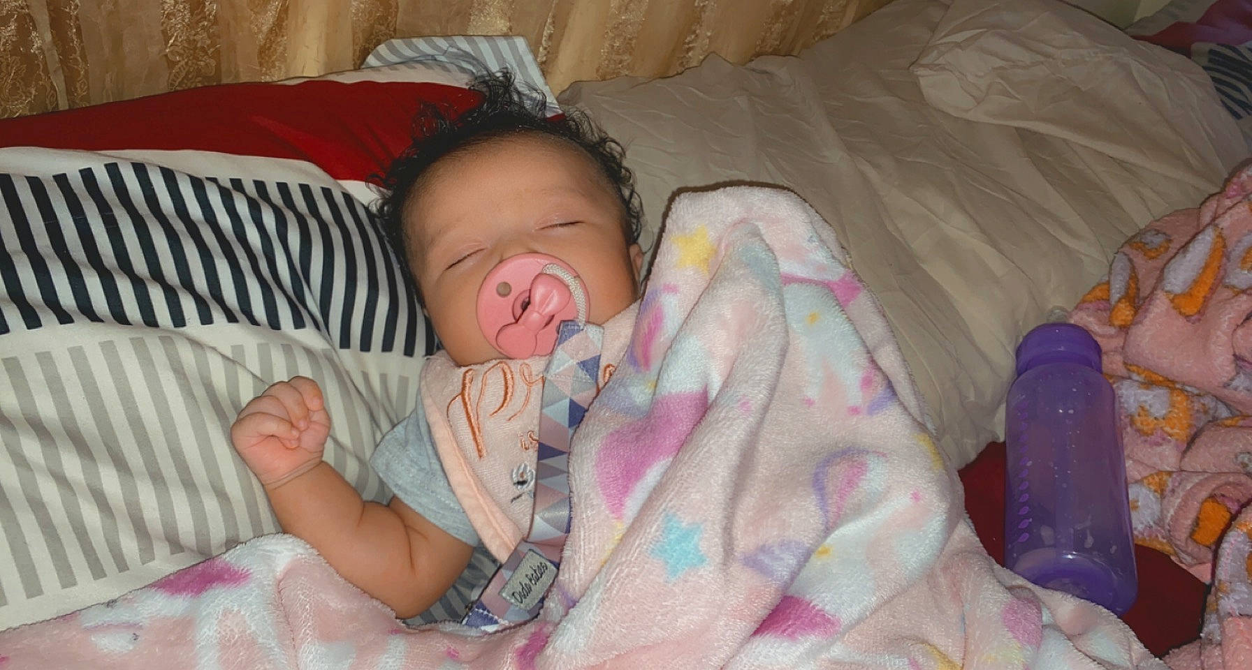 Estella is registered to the contest to win money with this photo: baby, baby_toddler_clothing, bed, bedding, bedtime, cheek, child, comfort, finger, fun, head, iris, linens, mouth, nap, person, pink, product, skin, thumb