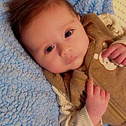 Ralph Bennett joined the competition — help win amazing prizes! baby, infant, face, hair, blanket, blue, brown_clothing, cute, portrait, child, hand, expression, lying_down, soft_texture, indoors, cozy, young, warm, adorable, sleepwear