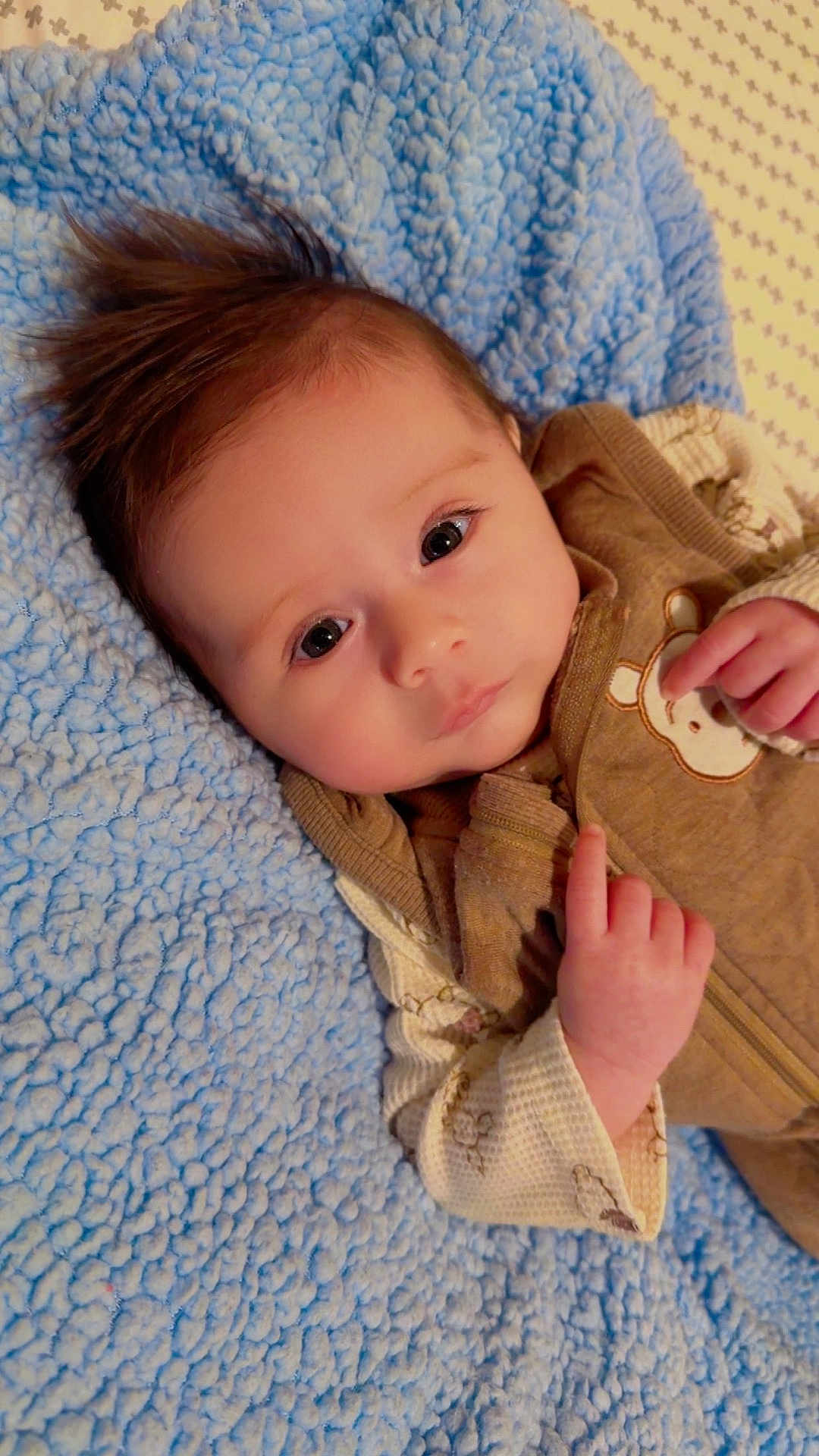 Ralph Bennett joined the competition — help win amazing prizes! baby, infant, face, hair, blanket, blue, brown_clothing, cute, portrait, child, hand, expression, lying_down, soft_texture, indoors, cozy, young, warm, adorable, sleepwear