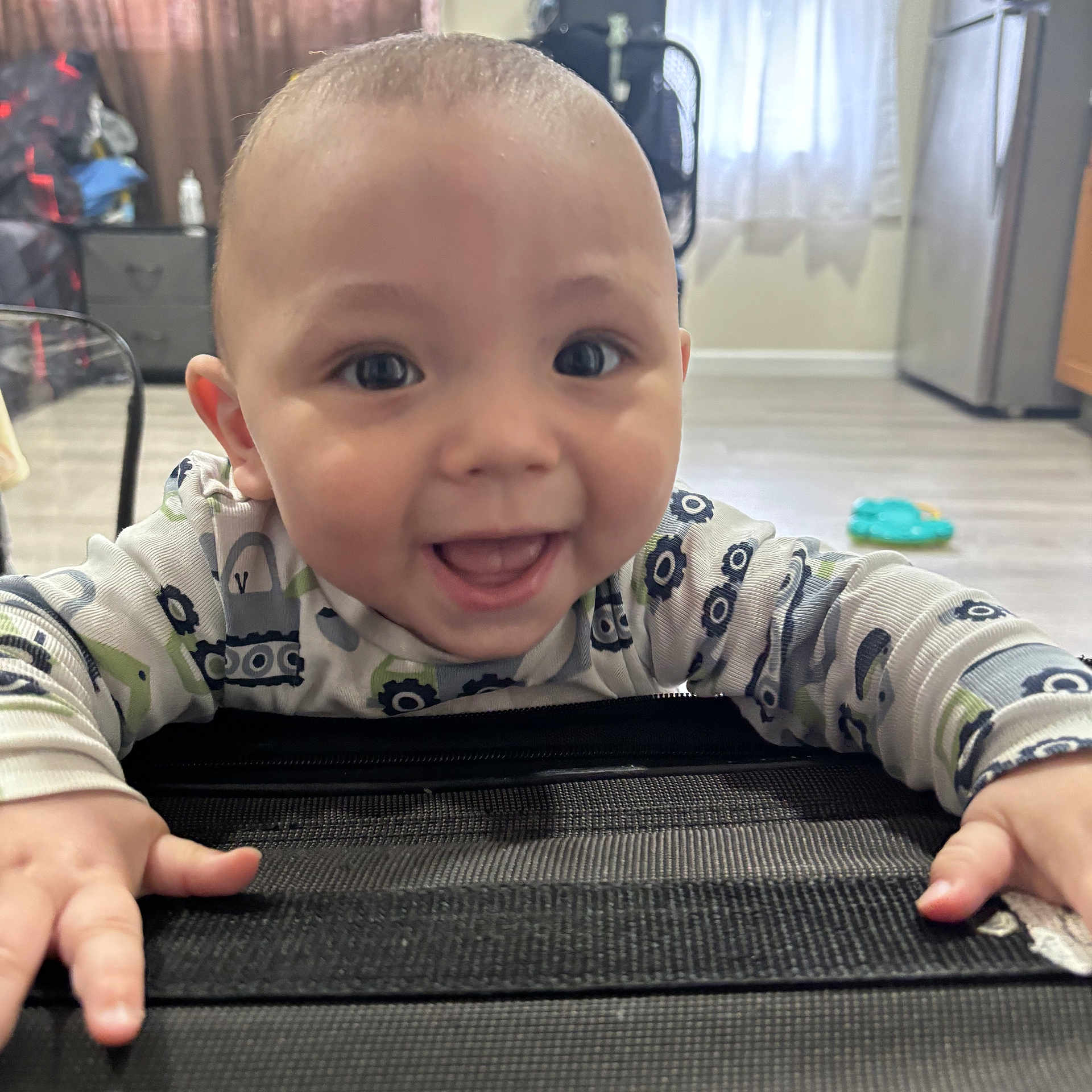 Raeleigh is registered to the contest to win money with this photo: baby, child, smile, happy, indoor, face, hands, curtain, fan, refrigerator, floor, clothing, person, infant, toy, window, home, eyes, mouth, expression